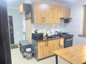 a kitchen with wooden cabinets and a sink and a stove at Apartment lux in Samarkand