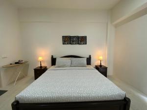 a bedroom with a large bed with two night stands at By The Sea @ Cozy Beachfront Home in Batu Ferringhi +157 photos