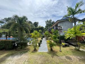 a house with a swimming pool and palm trees at BAAN CHAINARONG in Ko Lanta