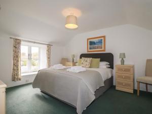 圣奥斯特尔Honeysuckle Cottage的一间卧室，配有一张大床和一扇窗户。