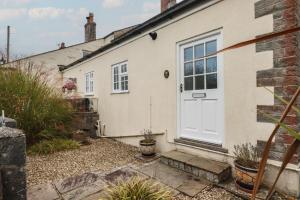 圣奥斯特尔Honeysuckle Cottage的白色的房子,有白色的门