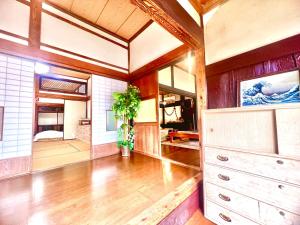 a large room with wooden floors and wooden walls at 和心村ー古民家とグランピングと自然森山川海 in Minato