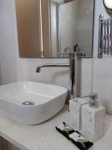 a bathroom with a white sink and a mirror at Pylea Beach Hotel in Ialyssos