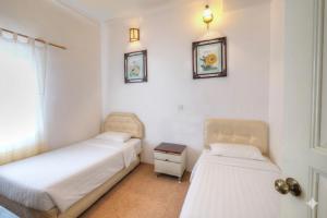 a bedroom with two beds and a table and two mirrors at Holiday Bungalow Suites - Sleeps Up To 26 Pax in Tanah Rata