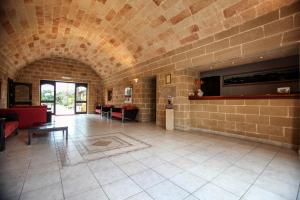 une grande chambre avec un mur en briques et un hall dans l'établissement Hotel Masseria Le Pajare, à Presicce