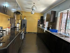 cocina grande con fregadero y nevera en Breeze and Branches, en Blantyre