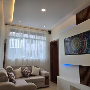 a living room with a couch and a tv at majesty beautiful suite in Cuenca