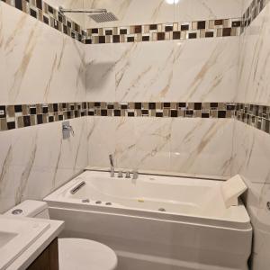 a white bathroom with a tub and a toilet at majesty beautiful suite in Cuenca