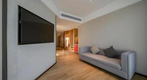 a living room with a couch and a flat screen tv at Echeng Hotel Nanning the Mixc Convention in Nanning
