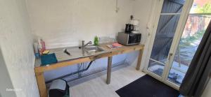 a kitchen with a sink and a microwave at Chalet Robinson, a 20 km de Disney et 50 de Paris - SNCF in Mortcerf