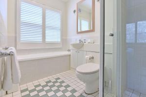 a white bathroom with a toilet and a sink at Villa 2br Pinot Nois Villa in Pokolbin +15 photos