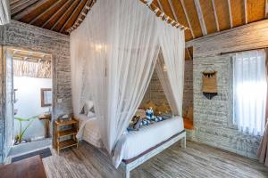 a bedroom with a bed with a canopy at Villa Cahaya - Ocean, sunset and volcano views, an island hideout in Nusa Ceningan