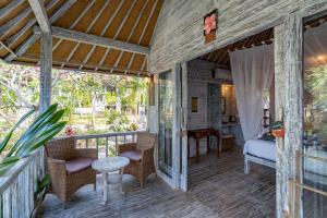 a room with a balcony with a bed and a table at Villa Cahaya - Ocean, sunset and volcano views, an island hideout in Nusa Ceningan +7 photos
