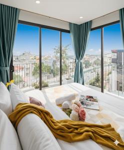 a white bed in a room with a large window at Label6 Coliving Rooftop Lakeview in Hanoi