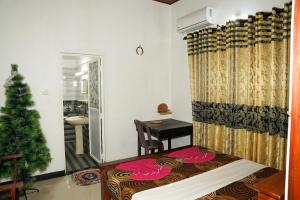 a bedroom with a christmas tree and a bed at Mango House River Inn Negombo in Kochchikade