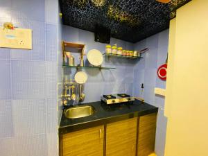 a small kitchen with a sink and mirrors on the wall at Hotel Aksa Palace in Mumbai