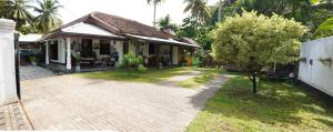 a house with a brick driveway in front of it at Mango House River Inn Negombo in Kochchikade