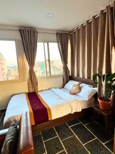 a bedroom with a bed with a large window at Deepjyoti Inn in Pashupatināth +44 photos
