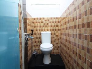 La salle de bains est pourvue de toilettes et d'un mur carrelé. dans l'établissement LUMUNGGA KOSTEL By Hans Management, à Lampung