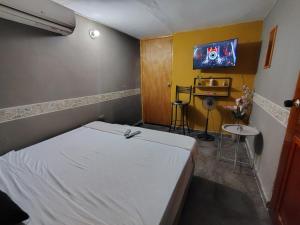 a bedroom with a bed and a tv on the wall at La Vie En Rose CTG in Cartagena de Indias