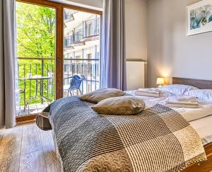 a bedroom with two beds and a large window at Apartament Góry i Las in Szklarska Poręba