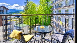 a balcony with a table and chairs on a balcony at Apartament Góry i Las in Szklarska Poręba