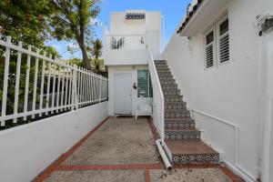 una escalera que conduce a una casa blanca en Ocean Park Studio Steps to beach Keyless entry, en San Juan