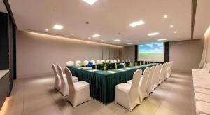 a conference room with a long green table and white chairs at Jinjiang Inn Shanghai Expo Park Pusan Rd in Shanghai