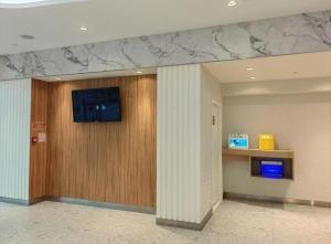 a lobby with a wall with a television on a column at Goodrich Hotel in Hong Kong