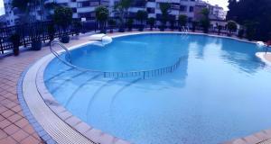 a large blue swimming pool in a building at Nanning Yongjiang Hotel in Nanning