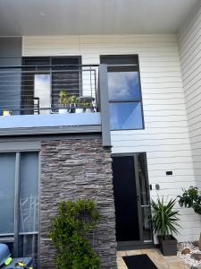 a house with a balcony with plants on it at Torquay Golf Retreats - Pool, Beach, Tennis, Golf in Torquay