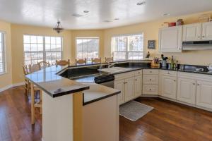 a large kitchen with white cabinets and a large island at Lone Eagle Haven home in Mesa