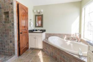 a bathroom with a tub and a sink and a window at Lone Eagle Haven home in Mesa +44 photos