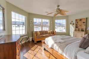 a bedroom with a bed and a couch and windows at Lone Eagle Haven home in Mesa