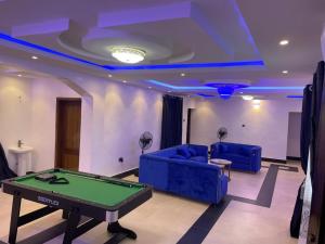 a living room with a pool table and blue lighting at A4 Service Apartment & Suite in Atan