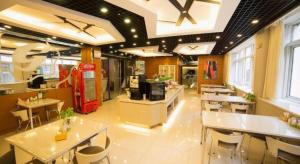 a restaurant with white tables and chairs and windows at Jinjiang Inn Style Shenyang The Palace Huaiyuan Gate in Shenyang