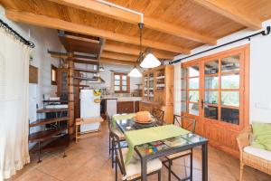 セルバにあるSa Garriga De Can Barratotの木製の天井とテーブル付きのキッチンとリビングルーム