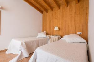 セルバにあるSa Garriga De Can Barratotのベッド2台 木製の壁の部屋