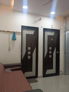 two doors in a room with a bed next to it at Mahadev hotel bambor in Jodhpur