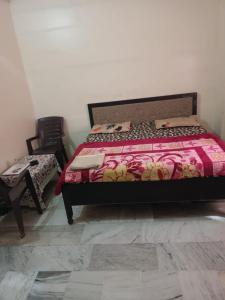 a bedroom with a bed and a chair at Mahadev hotel bambor in Jodhpur