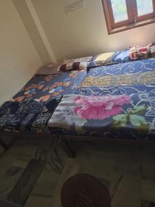 a bed with a colorful quilt on it in a room at Mahadev hotel bambor in Jodhpur