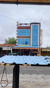 a large building with blue roofs in front of a street at Mahadev hotel bambor in Jodhpur