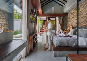 een man en een vrouw die in een slaapkamer staan bij Vinna Villa Seminyak by The Wina Resorts in Kerobokan +50 foto's