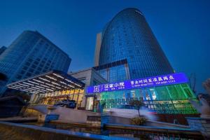 two tall buildings in a city at night at Hundred Hotel Qingdao in Qingdao