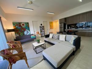 a living room with a couch and a table at By The Sea@ Cozy Beachfront Home (Batu Ferringhi). in Batu Ferringhi