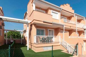 a pink house with a balcony and a yard at Mar de Coral in El Verger