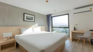 a bedroom with a large white bed and a window at B2 Don Mueang Premier Hotel in Bangkok +44 photos