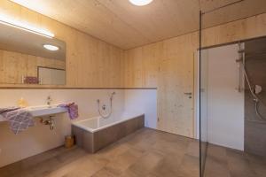 a bathroom with a tub and a sink and a shower at Luxury Naturperle Haus Alpenprinzessin helles Holzhaus zentral , modern & großräumig in Neustift im Stubaital