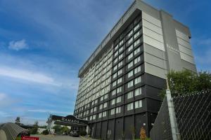 Un edificio alto con un cartel al costado. en Ramada by Wyndham North Bergen, en North Bergen