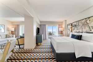 a hotel room with a large bed and a living room at Hyatt Centric Delfina Santa Monica in Los Angeles